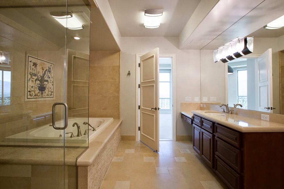 Design ideas for a mid-sized midcentury master bathroom in Las Vegas with a drop-in sink, raised-panel cabinets, dark wood cabinets, granite benchtops, a drop-in tub, a corner shower, beige tile, beige walls and marble floors.