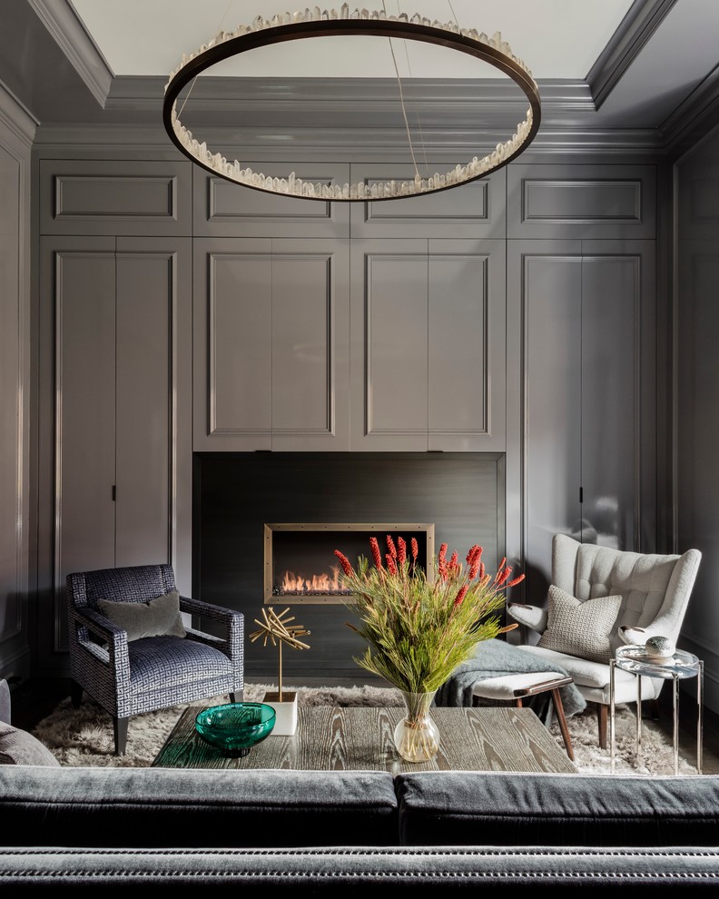Inspiration for a large transitional enclosed living room in Boston with a home bar, grey walls, dark hardwood floors, a standard fireplace, a metal fireplace surround, no tv and brown floor.
