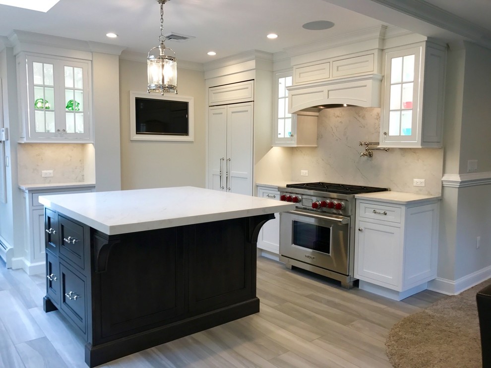 Open concept kitchen - mid-sized transitional u-shaped light wood floor and brown floor open concept kitchen idea with a farmhouse sink, recessed-panel cabinets, white cabinets, marble countertops, white backsplash, marble backsplash, stainless steel appliances and an island