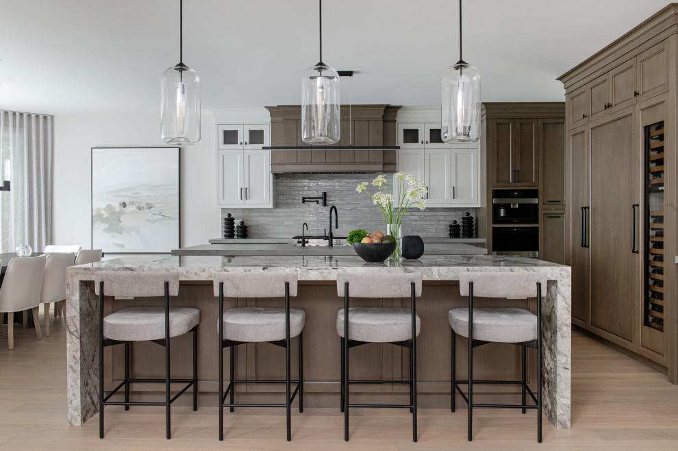 Inspiration for a mid-sized transitional l-shaped medium tone wood floor eat-in kitchen remodel in Toronto with an undermount sink, recessed-panel cabinets, medium tone wood cabinets, multicolored countertops and two islands