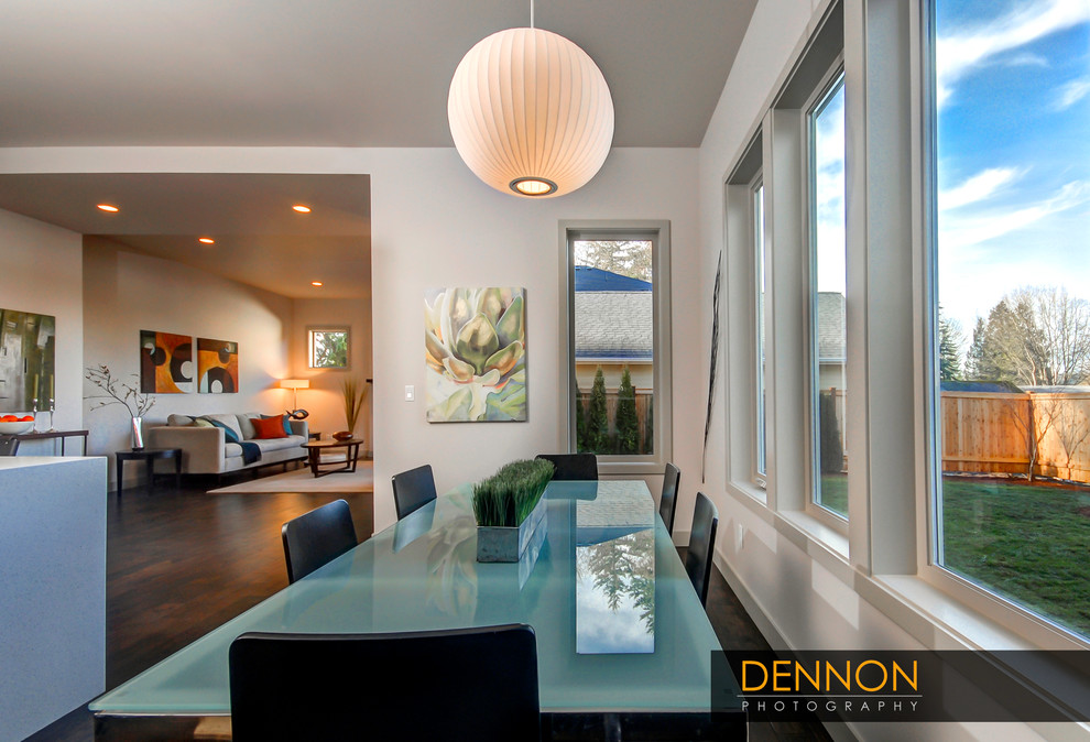 This is an example of a mid-sized transitional open plan dining in Seattle with white walls, dark hardwood floors, no fireplace and brown floor.