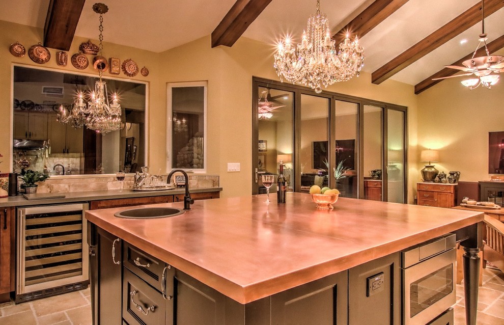 This is an example of a mid-sized eclectic eat-in kitchen in Phoenix with a single-bowl sink, black cabinets, copper benchtops, stainless steel appliances, porcelain floors, with island and beige floor.