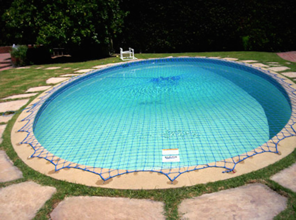 Example of a mid-sized backyard stone and round pool design in Miami