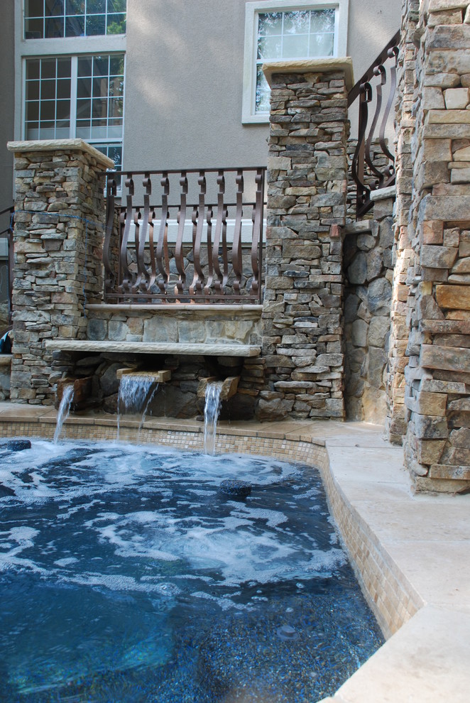 Inspiration for a large country backyard custom-shaped pool in Other with a water feature and concrete pavers.