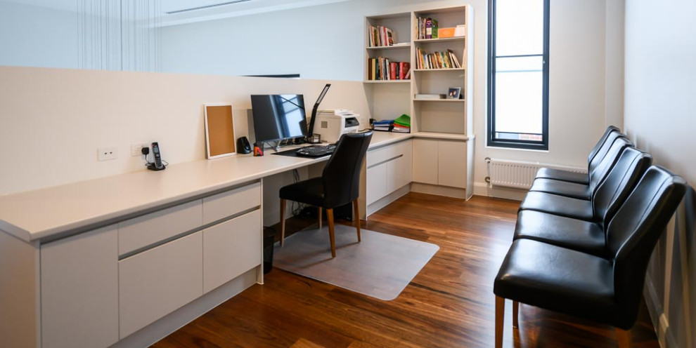 Источник вдохновения для домашнего уюта: кабинет среднего размера в стиле модернизм с белыми стенами, паркетным полом среднего тона и встроенным рабочим столом