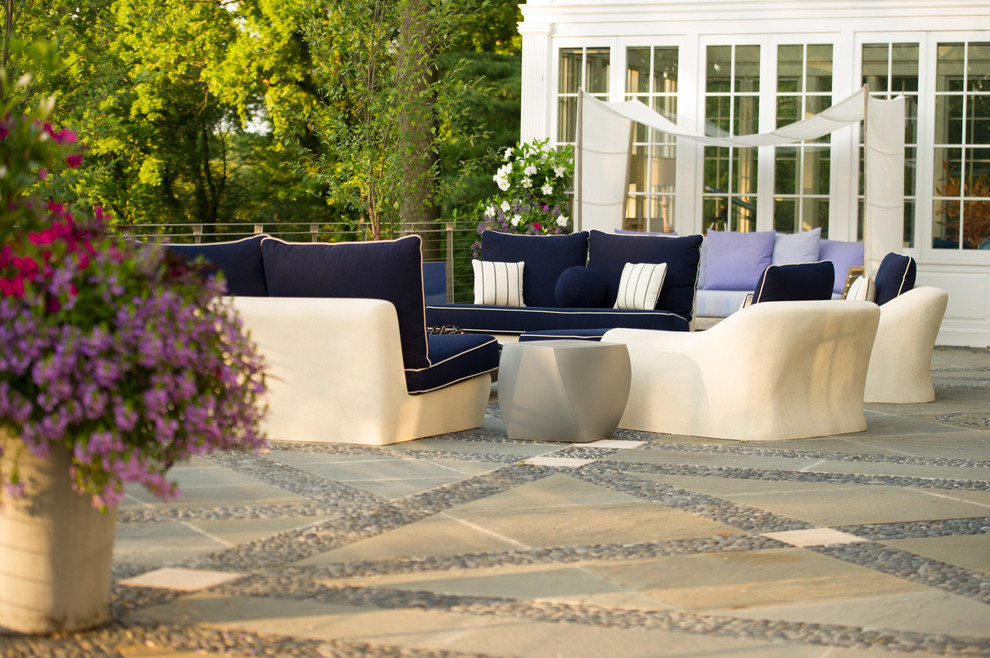 Example of a large transitional backyard stone patio design in New York with no cover and a fire pit