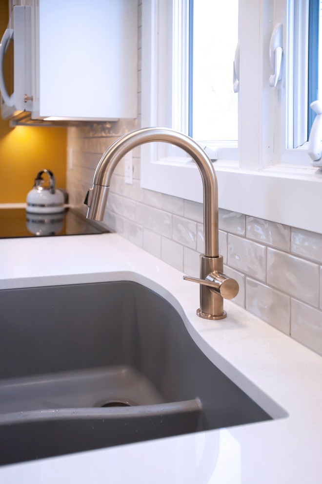Mid-sized transitional single-wall eat-in kitchen photo with an undermount sink, shaker cabinets, white cabinets, quartz countertops, porcelain backsplash, stainless steel appliances, no island and white countertops