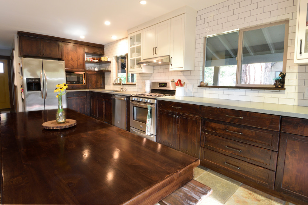 This is an example of a mid-sized country l-shaped eat-in kitchen in Sacramento with an undermount sink, shaker cabinets, dark wood cabinets, quartzite benchtops, white splashback, cement tile splashback, stainless steel appliances, terrazzo floors and brown floor.