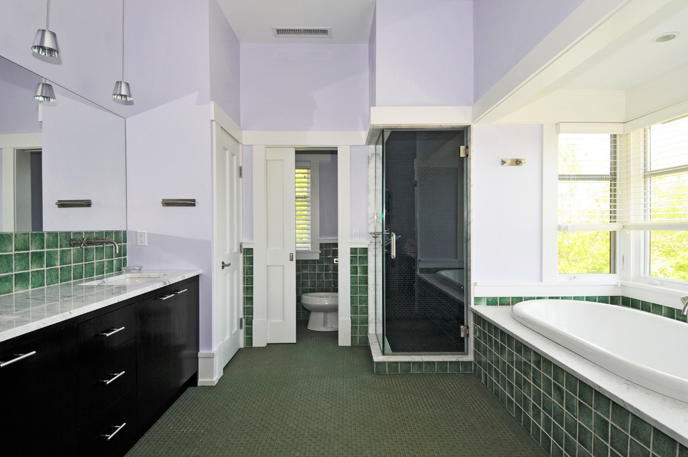 Large transitional master bathroom in New York with flat-panel cabinets, black cabinets, a drop-in tub, a corner shower, a one-piece toilet, green tile, porcelain tile, purple walls, an undermount sink and marble benchtops.