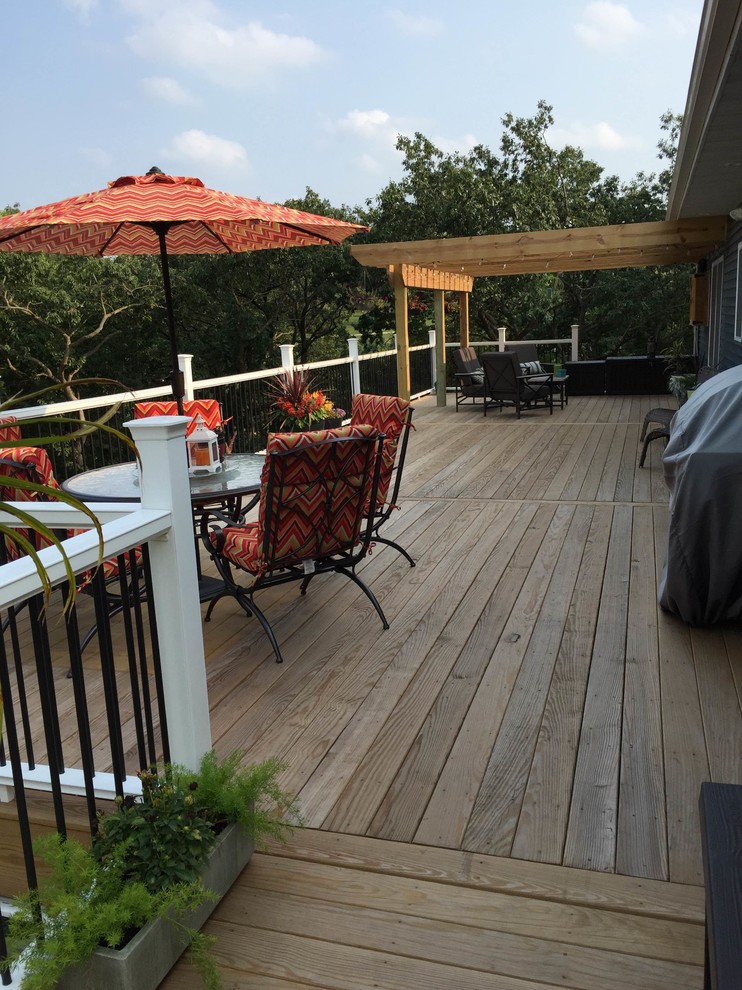 Inspiration for a backyard deck remodel in Cedar Rapids with a pergola