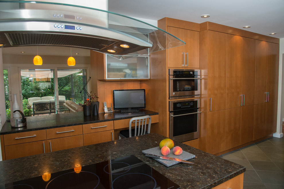 Photo of a mid-sized contemporary galley separate kitchen in New York with an undermount sink, flat-panel cabinets, medium wood cabinets, granite benchtops, stainless steel appliances, ceramic floors and with island.