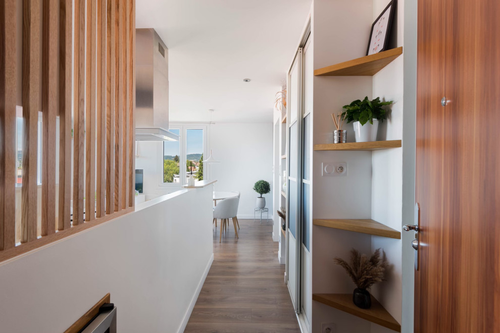 Example of a mid-sized danish light wood floor and brown floor entry hall design in Lyon with white walls