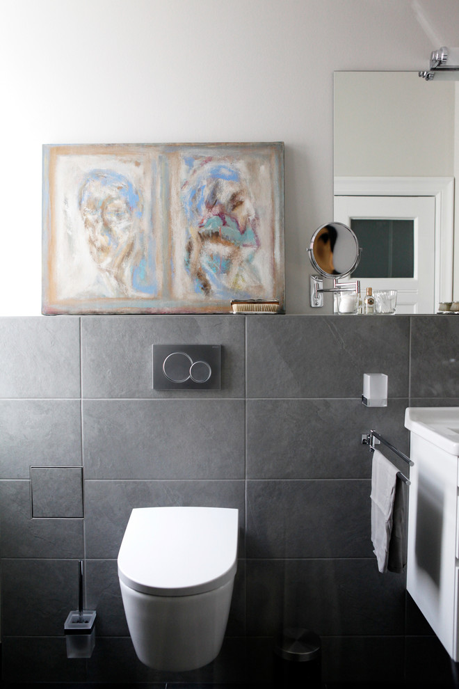 Photo of a mid-sized 3/4 bathroom in Berlin with a curbless shower, gray tile, stone tile, grey walls, grey floor and a hinged shower door.