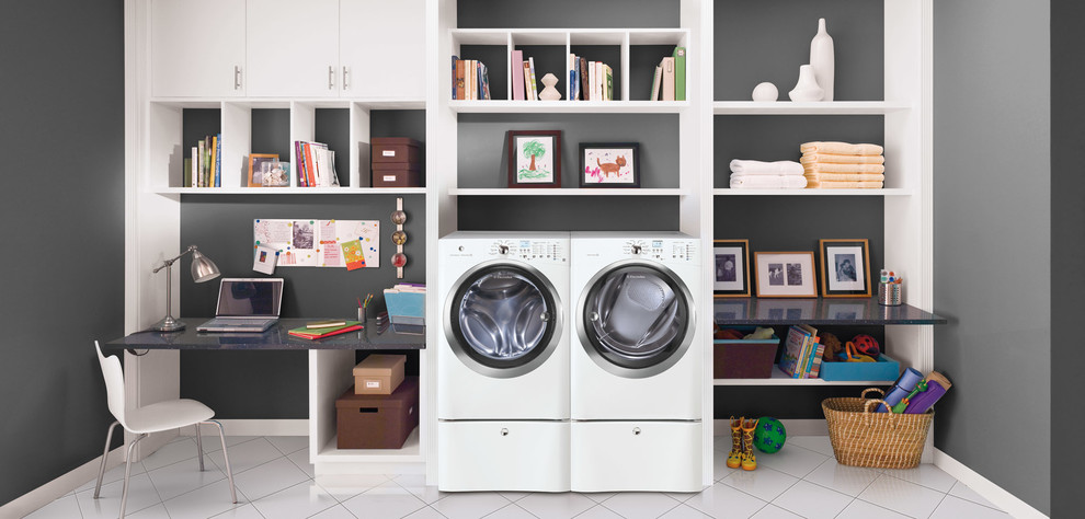 Design ideas for a mid-sized modern dedicated laundry room in Bridgeport with flat-panel cabinets, white cabinets, granite benchtops, ceramic floors, a stacked washer and dryer and grey walls.