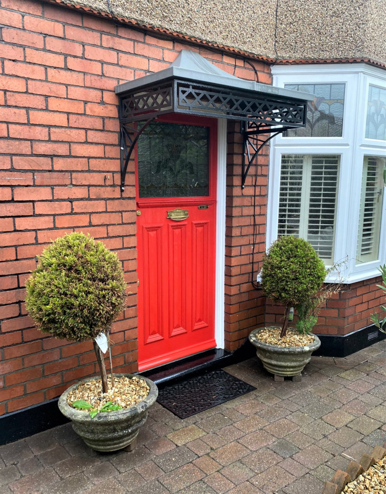 Aménagement d'une petite porte d'entrée classique avec une porte simple et une porte rouge.