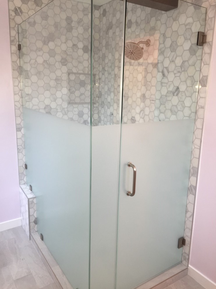 Mid-sized contemporary master bathroom in Los Angeles with a freestanding tub, a corner shower, gray tile, white tile, a one-piece toilet, pink walls, a hinged shower door, furniture-like cabinets, grey cabinets, an undermount sink, grey floor, marble, medium hardwood floors, quartzite benchtops and grey benchtops.