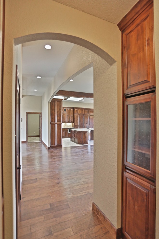 Mid-sized country hallway in Dallas with beige walls and medium hardwood floors.