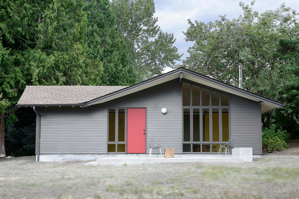 Photo of a mid-sized midcentury one-storey grey exterior in Seattle with a gable roof.