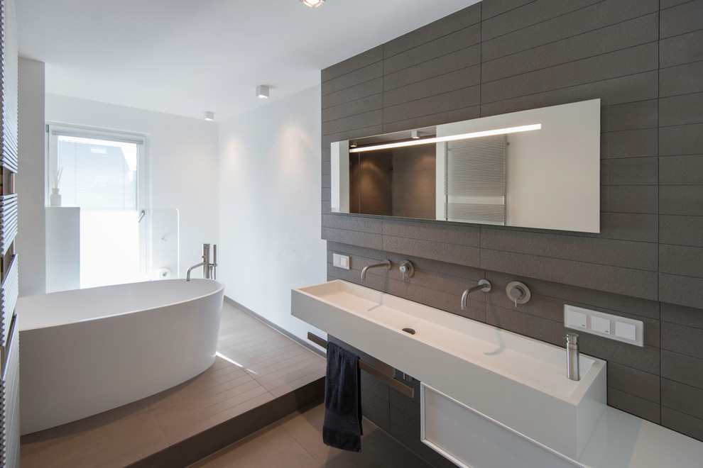 Modernes Badezimmer mit freistehender Badewanne, bodengleicher Dusche, Wandtoilette, blauen Fliesen, Keramikfliesen, weißer Wandfarbe, Keramikboden und Trogwaschbecken in Frankfurt am Main