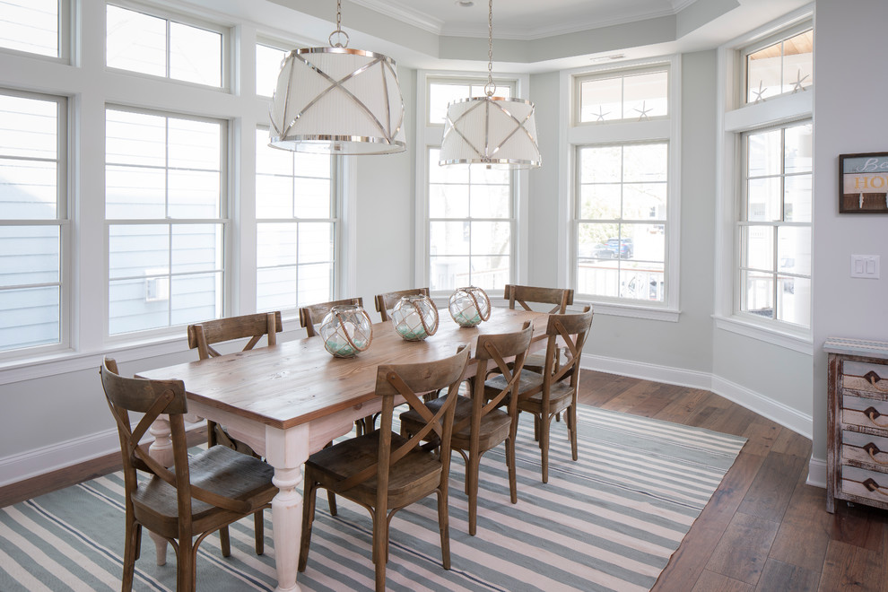 Inspiration for a beach style dining room in New York with grey walls, dark hardwood floors and brown floor.