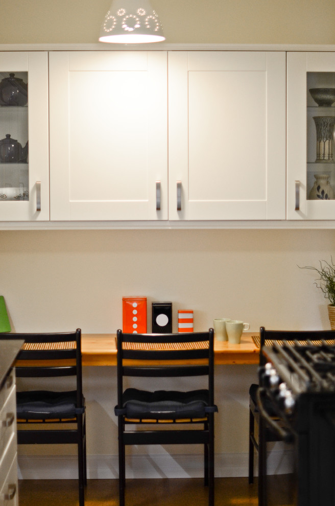 Inspiration for a small transitional galley cork floor kitchen remodel in Ottawa with an undermount sink, shaker cabinets, white cabinets, quartz countertops, white backsplash, porcelain backsplash and black appliances