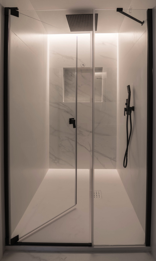 Inspiration för ett mellanstort nordiskt vit vitt en-suite badrum, med släta luckor, vita skåp, en dusch i en alkov, ett urinoar, svart och vit kakel, keramikplattor, vita väggar, ett nedsänkt handfat, vitt golv och dusch med gångjärnsdörr