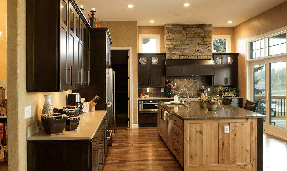 Example of a large transitional l-shaped dark wood floor kitchen design with an undermount sink, recessed-panel cabinets, dark wood cabinets, stainless steel appliances and an island