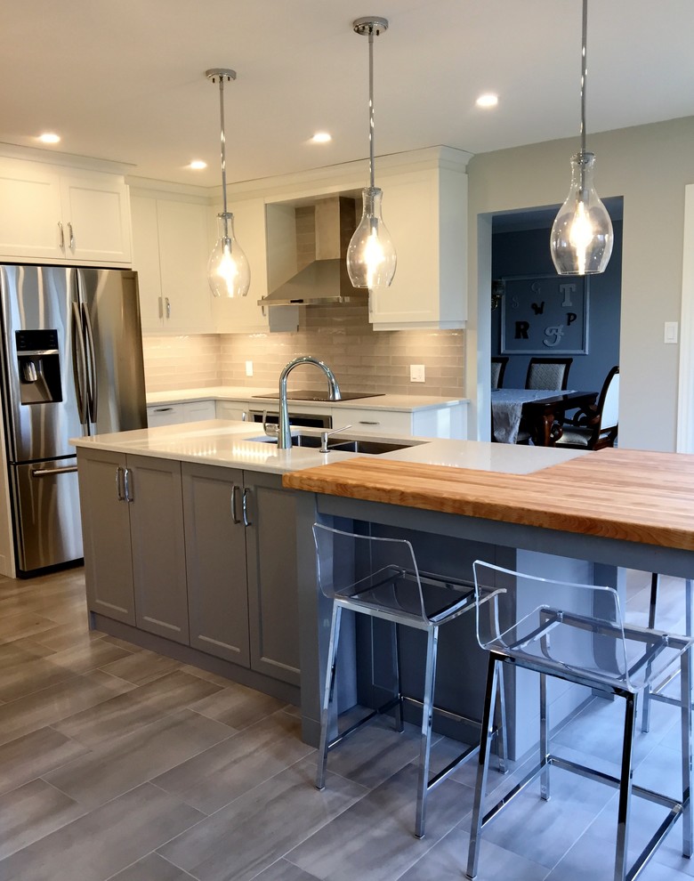 Large transitional u-shaped ceramic tile eat-in kitchen photo in Ottawa with an undermount sink, shaker cabinets, white cabinets, gray backsplash, subway tile backsplash, stainless steel appliances, an island and quartzite countertops