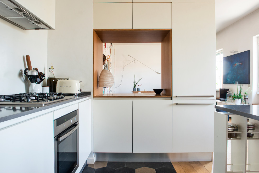 Idéer för ett mycket stort modernt grå kök, med en undermonterad diskho, släta luckor, vita skåp, bänkskiva i kvarts, vitt stänkskydd, rostfria vitvaror, cementgolv, en halv köksö och flerfärgat golv
