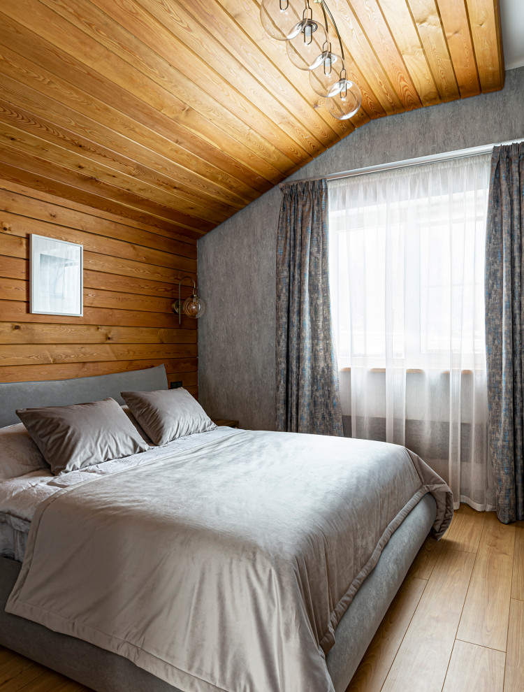 Foto di una piccola camera da letto design con pareti grigie, pavimento in laminato, pavimento giallo, soffitto in perlinato e pareti in legno