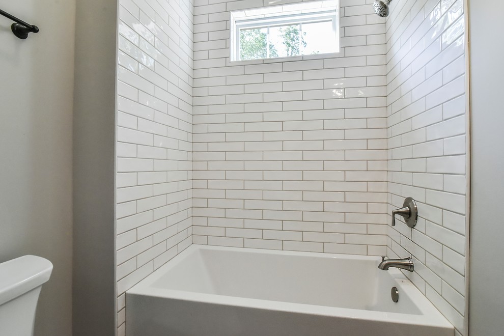 Inspiration for a mid-sized country bathroom in Other with shaker cabinets, white cabinets, a drop-in tub, a shower/bathtub combo, a two-piece toilet, gray tile, stone tile, grey walls, vinyl floors, an undermount sink, granite benchtops, brown floor, an open shower and beige benchtops.