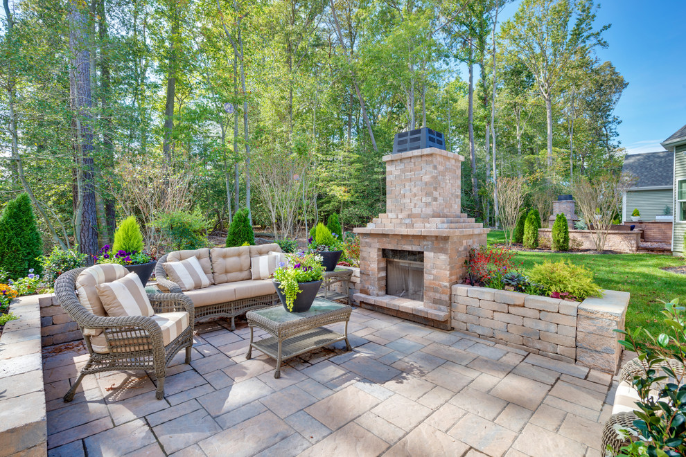 Photo of a mid-sized traditional backyard patio in Other with a fire feature and concrete pavers.