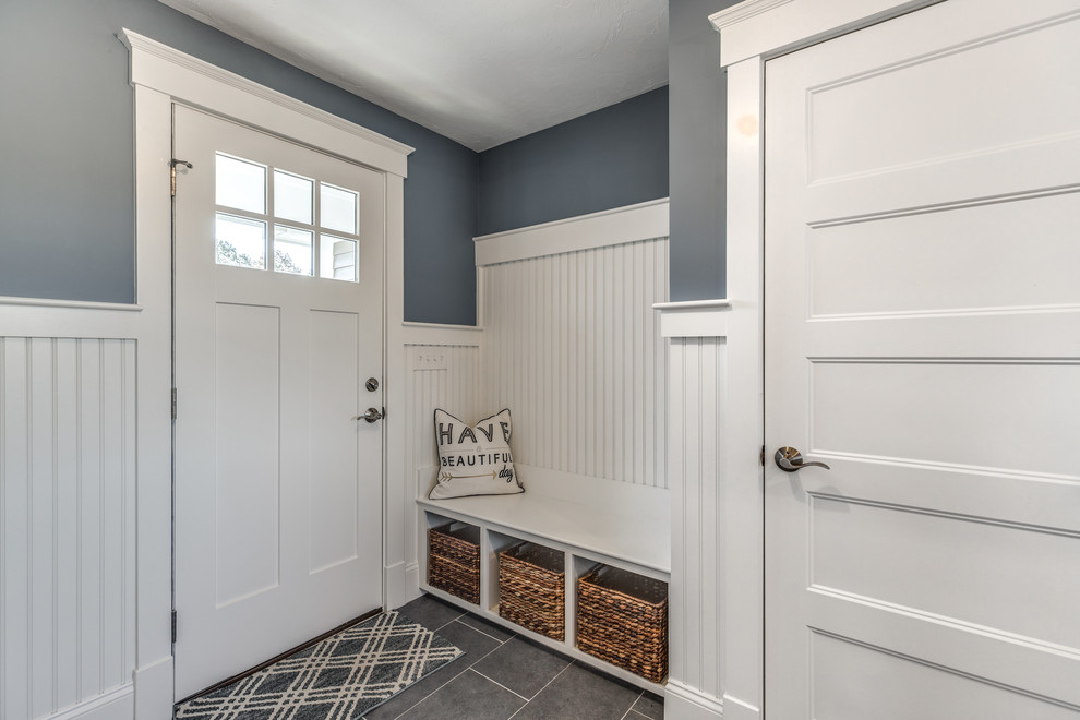 This is an example of a mid-sized mudroom in Boston with blue walls, ceramic floors, a single front door and a blue front door.