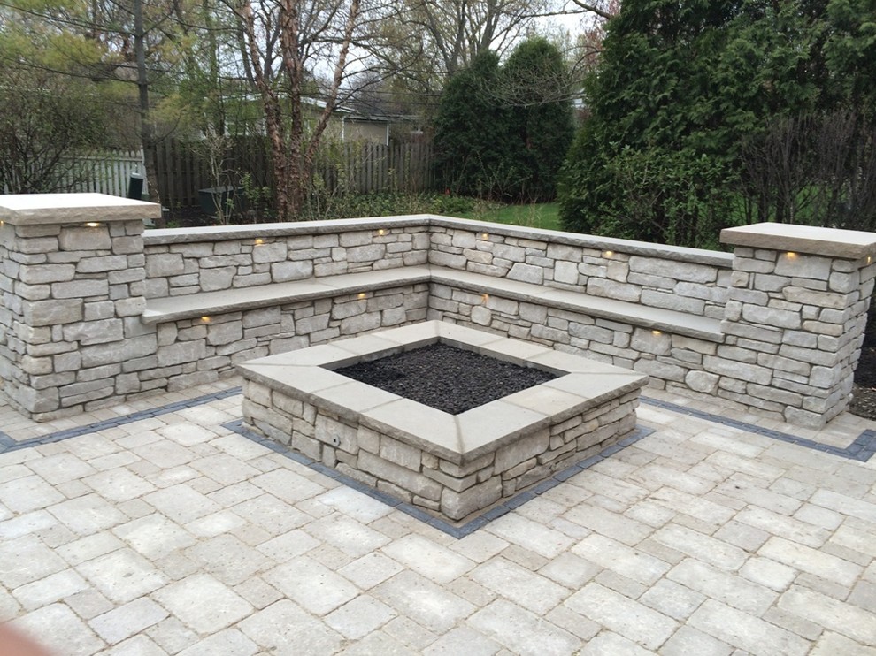 Inspiration for a large traditional backyard patio in Chicago with a fire feature, natural stone pavers and no cover.