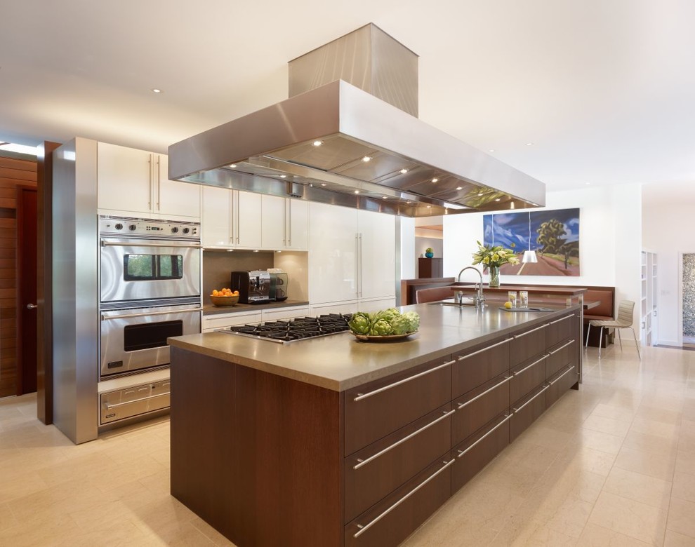 This is an example of a mid-sized contemporary single-wall eat-in kitchen in Miami with a double-bowl sink, beaded inset cabinets, white cabinets, terrazzo benchtops, brown splashback, stainless steel appliances, travertine floors and with island.