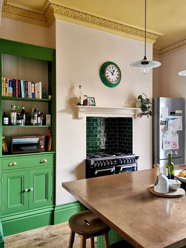 Klassisk inredning av ett mellanstort brun brunt kök och matrum, med en rustik diskho, skåp i shakerstil, gröna skåp, bänkskiva i akrylsten, grönt stänkskydd, stänkskydd i keramik, integrerade vitvaror, mellanmörkt trägolv, en köksö och brunt golv