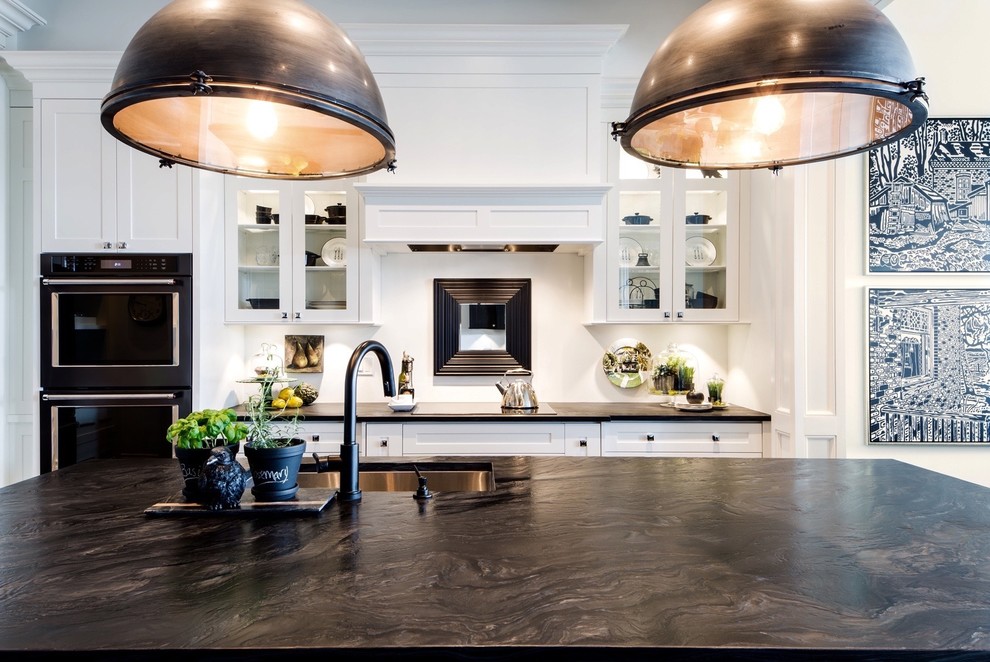 Open concept kitchen - large contemporary galley medium tone wood floor and brown floor open concept kitchen idea with an undermount sink, shaker cabinets, white cabinets, granite countertops, white backsplash, stainless steel appliances and an island