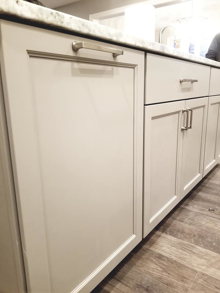 Kitchen - transitional brown floor kitchen idea with an undermount sink, flat-panel cabinets, white cabinets, quartzite countertops, white backsplash, subway tile backsplash, stainless steel appliances and an island