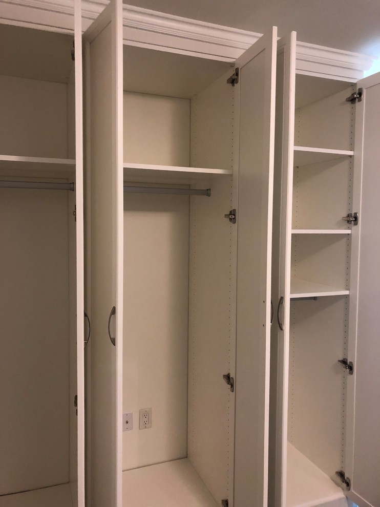 Inspiration for a mid-sized traditional gender-neutral built-in wardrobe in Toronto with recessed-panel cabinets, white cabinets, slate floors and black floor.