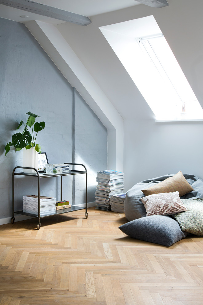 This is an example of a scandinavian family room in Copenhagen with grey walls and light hardwood floors.