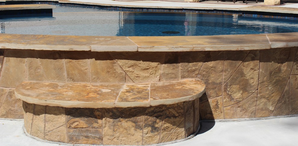 Design ideas for a large tropical backyard round natural pool in Houston with a hot tub and concrete pavers.