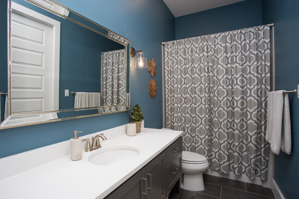 Example of a mid-sized transitional 3/4 white tile and subway tile ceramic tile and gray floor alcove bathtub design in Austin with shaker cabinets, gray cabinets, a two-piece toilet, blue walls, an undermount sink and quartz countertops