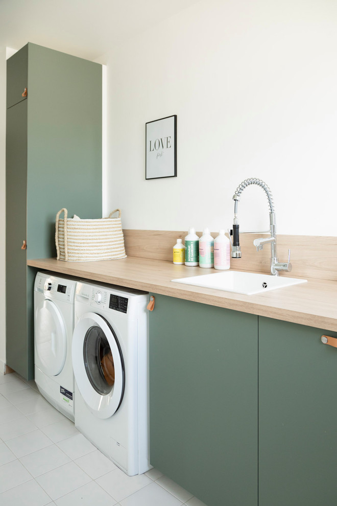 Design ideas for a medium sized contemporary single-wall separated utility room in Paris with a built-in sink, beaded cabinets, green cabinets, wood worktops, beige splashback, wood splashback, white walls, ceramic flooring, a side by side washer and dryer, white floors and beige worktops.