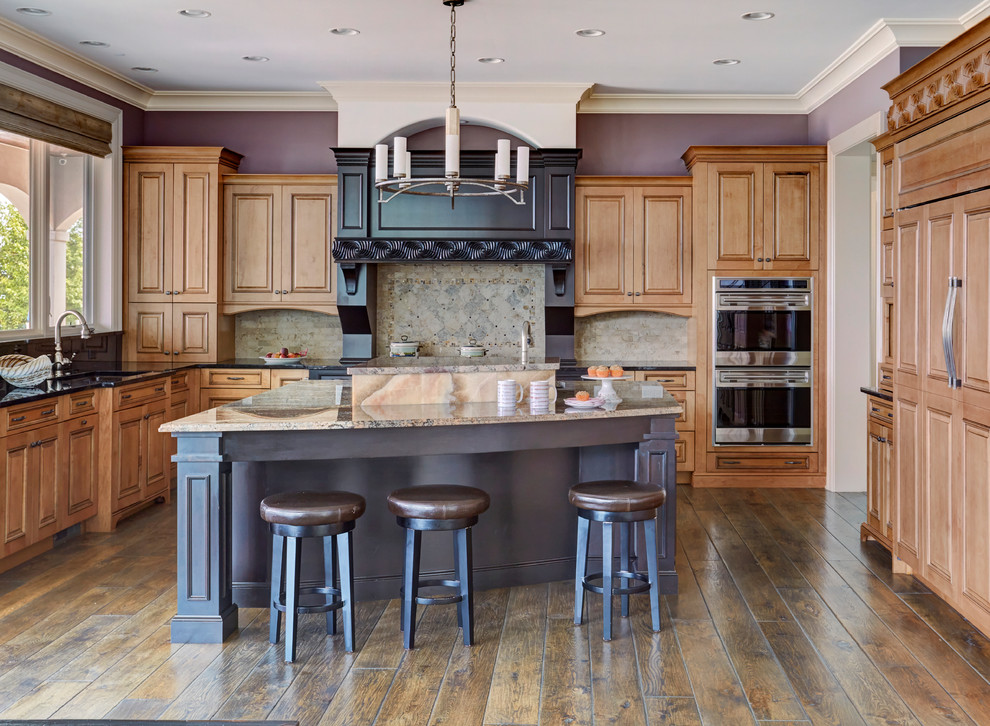 Inspiration for a large traditional u-shaped open plan kitchen in Chicago with an undermount sink, raised-panel cabinets, medium wood cabinets, grey splashback, stainless steel appliances, dark hardwood floors, with island, brown floor, beige benchtop, granite benchtops and porcelain splashback.