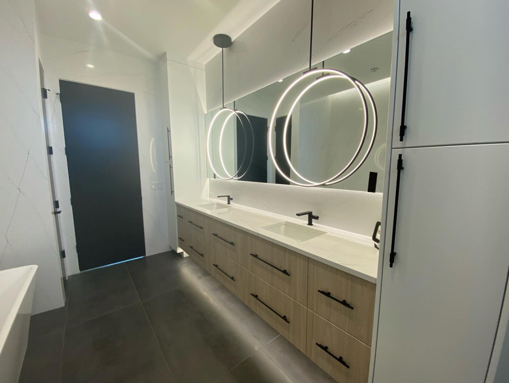 This is an example of an expansive urban bathroom in Other with flat-panel cabinets, light wood cabinets, white tiles, porcelain flooring, engineered stone worktops, grey floors, white worktops, double sinks and a floating vanity unit.