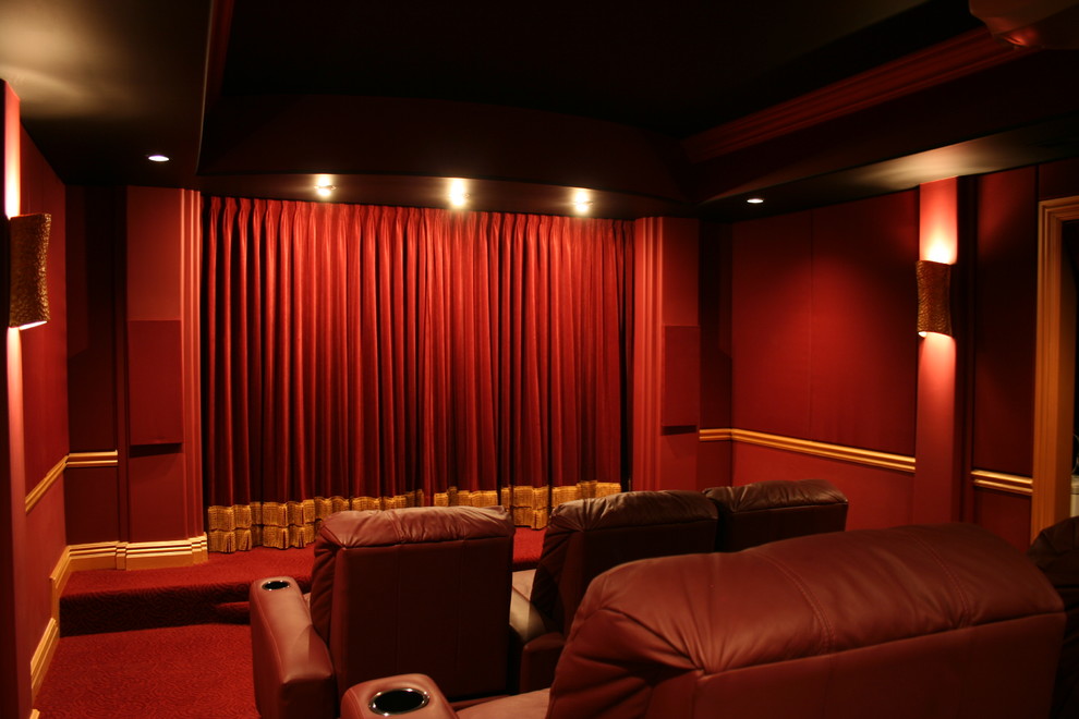 Photo of a traditional enclosed home theatre in Chicago with red walls, carpet, a projector screen and red floor.
