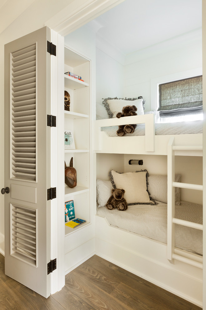 This is an example of a beach style gender-neutral kids' bedroom for kids 4-10 years old in Atlanta with white walls and light hardwood floors.