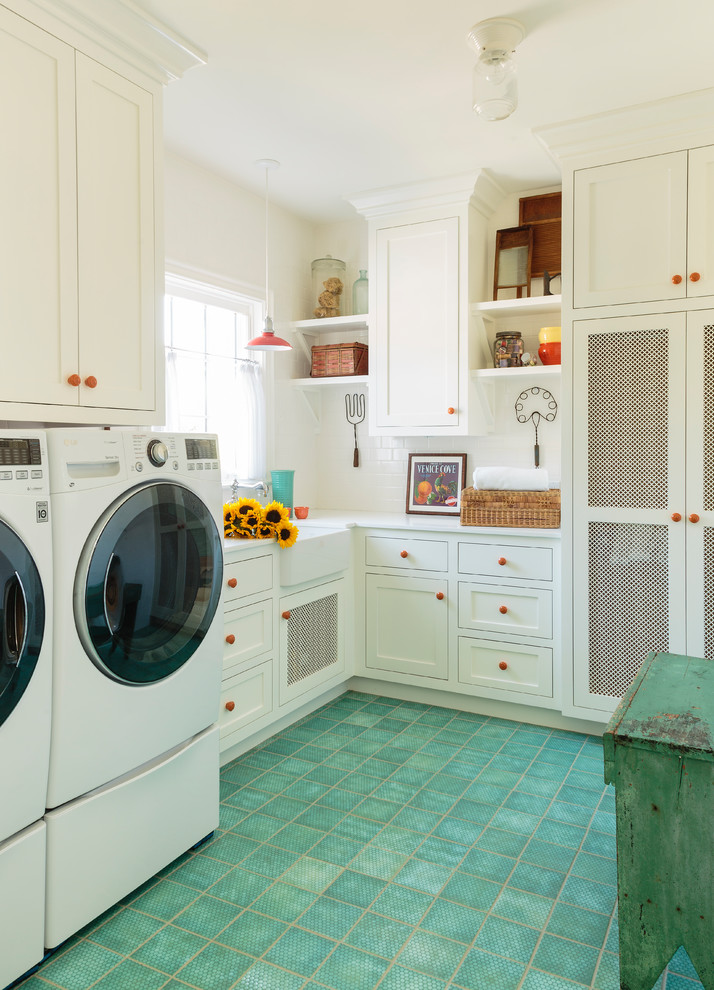 This is an example of a large country dedicated laundry room in Los Angeles with a farmhouse sink, shaker cabinets, white cabinets, quartz benchtops, white walls, ceramic floors, a side-by-side washer and dryer, green floor and white benchtop.