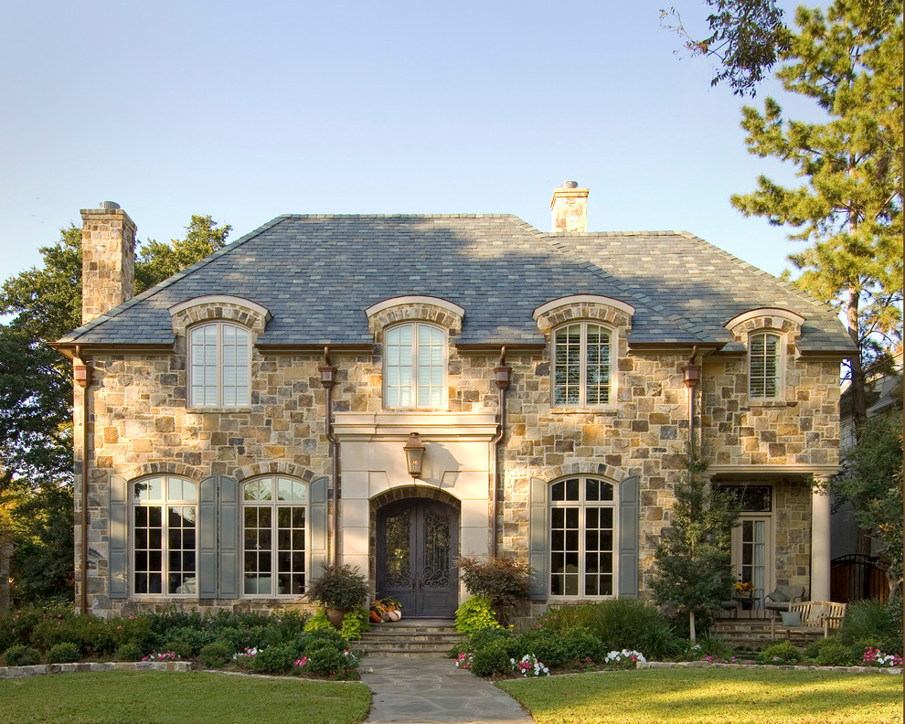 Traditional two-storey beige exterior in Dallas with stone veneer and a hip roof.
