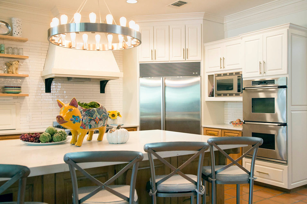 Example of a large southwest u-shaped dark wood floor and brown floor open concept kitchen design in Austin with raised-panel cabinets, quartz countertops, white backsplash, ceramic backsplash, stainless steel appliances and an island
